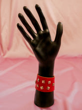 Load image into Gallery viewer, red leather wrap cuff with silver studs on a black mannequin hand red jewelry

