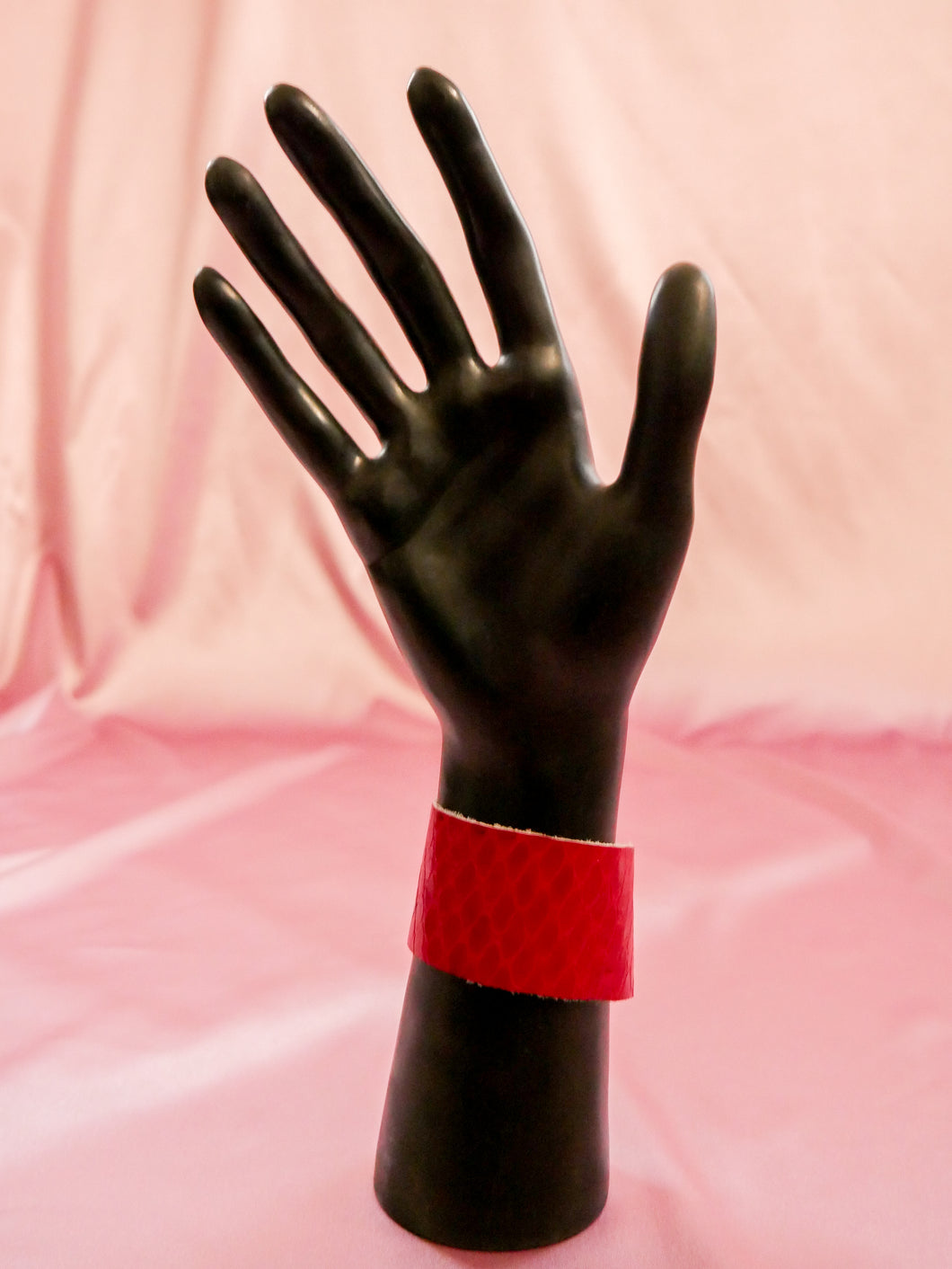 red faux snakeskin wrap bracelet women's jewelry on a black mannequin hand